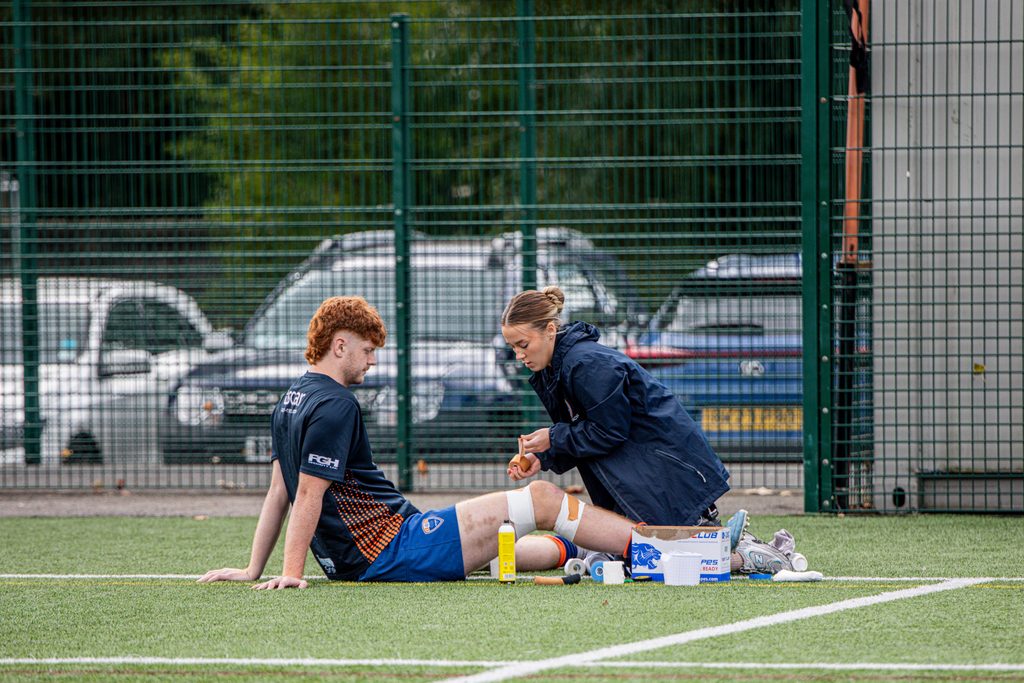 Football injury warning signs: cold pack strapped around a knee